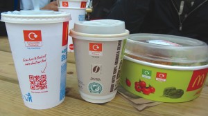 The color-coding was also utilized on the packaging and service ware — as shown above in the top symbol on the McDonald’s cups and container — to match with the proper receptacle, in this case, orange for composting.
