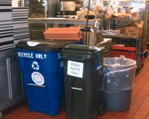 Well-marked and color coordinated food waste containers are placed in the central kitchen.