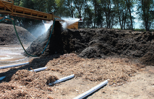 A pair of 1.5-inch fire hoses and nozzles were attached to the end of the piler and hooked to the site’s water truck to wet the ground materials as they discharged.