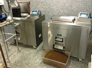 One dehydrator is being filled (on left), while the second has finished the drying cycle and is unloading (above).