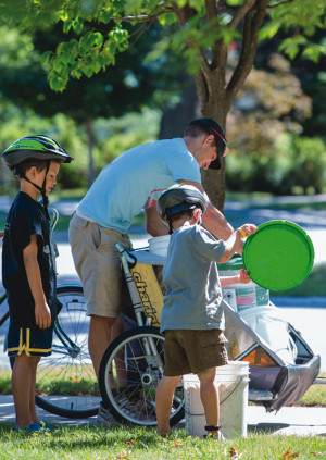 Ty Schmidt (middle), with sons Carter (left) and Jameson (right), work together to collect food scraps from their customers. Carter’s Compost employs the services of Jameson and three other kids in Traverse City to “sling buckets” and assist their neighbors in diverting food scraps from disposal. Photo by Beth Price