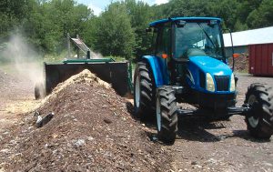 To form a windrow, wood chips are laid down, followed by food waste and sawdust as well as shredded paper and waxed containers.