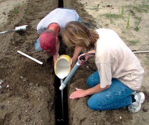 Contact water was captured through use of 10 ceramic collection suction tubes known as lysimeters placed underneath and surrounding the active composting pile (lysimeter installation shown in photo).