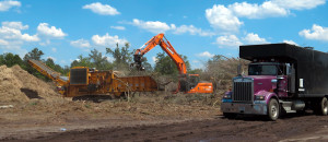 Southern Disaster Recovery offloads storm debris at a Collection Operations and Debris Management site (left) during a 2014 ice storm in South Carolina. Mobile processing equipment includes a CBI horizontal grinder (right).