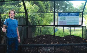 A Gainesville Compost staff member stands next to a steel, 3-bin composting system manufactured by Kanner Karts, available at bikecompost.com. 