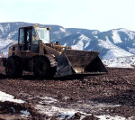 Operators at the PCSWC composting facility use a front-end loader to turn windrow piles. Feedstocks processed include yard trimmings, food waste and biosolids.
