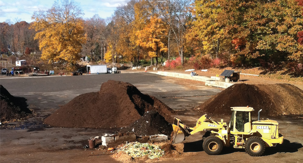 Food scraps are unloaded on a bed of horse manure to absorb liquids. Carbon is then added in the form of wood chips, leaves and/or additional manure and the materials are mixed with a front-end loader.
