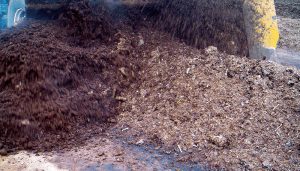 Manure and locally available carbon sources are mixed on concrete pads next to the high-rise houses. Photo courtesy of Brown Bear Corp.