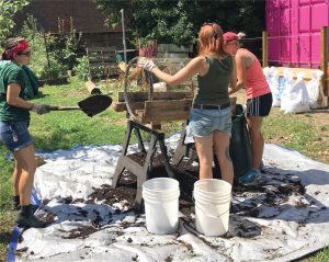 Working members of The Compost Coop help build a second trommel sifter. 