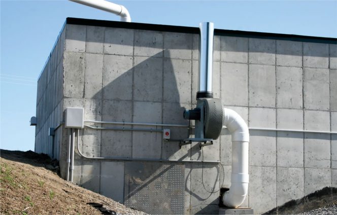 An induced draft fan can pull odorous air out of the head space over a tipping tank and send it to an odor treatment system such as a biofilter (above).