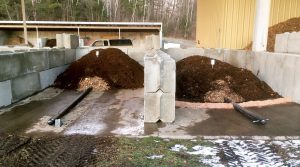 Perforated pipes on top of the concrete pad are manifolded to a series of fans. The site has capacity to compost 8 to 10 tons/week of food scraps.