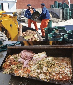 Postconsumer food scraps are collected from several prisons in the complex in 22-gallon barrels (top). Wood chips provided by tree trimmers are mixed with the food waste using a bucket loader.