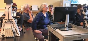 Author Deborah Neher (center) and University of Vermont students in her soil ecology class observe soil protozoa using compound light microscopes.