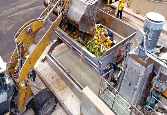 Food waste from commercial generators is loaded into a hopper with augers that move the material to the bioseparators.