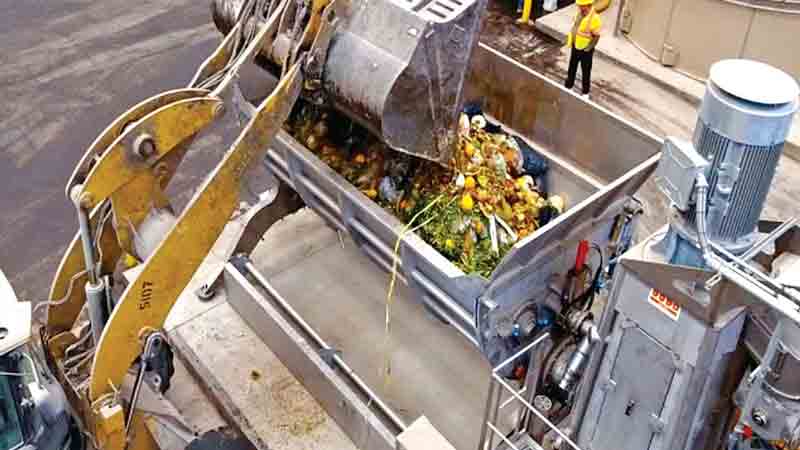 Food waste from commercial generators is loaded into a hopper with augers that move the material to the bioseparators.